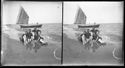 Guido Guerrini e tre uomini seduti sulla battigia: in secondo piano una barca ormeggiata nella riva: Bellaria