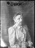 Ritratto di Maria Nigrisoli con un abito a quadretti: set fotografico allestito con un telo con motivo a griglia rettangolare