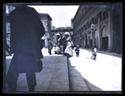 Un uomo con una borsa e tre donne che salgono la scalinata della basilica di San Petronio dal lato del Portico e Palazzo dei Banchi: prospetto della piazza Vittorio Emanuele II e della via Rizzoli: Bologna