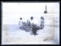 Un pescatore seduto sulla spiaggia con la famiglia e una barca che naviga verso la riva: Bellaria