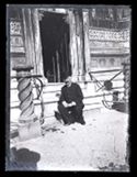 Un uomo seduto sul gradino dell’ingresso secondario di una chiesa