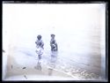 Una bambina di spalle e un’altra bambina con un infante nella riva: Bellaria