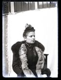 Ritratto di Maria Nigrisoli con il cappello, il cappotto e la stola di pelliccia: set fotografico allestito nel cortile interno della Biblioteca Universitaria di Bologna