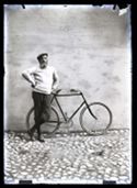 Olindo Guerrini in posa, appoggiato ad un muro con la bicicletta