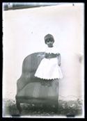 Ritratto di una bambina in piedi su una poltrona: set fotografico allestito nel cortile interno della Biblioteca Universitaria di Bologna