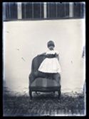 Ritratto di una bambina in piedi su una poltrona: set fotografico allestito nel cortile interno della Biblioteca Universitaria di Bologna