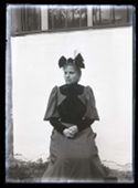 Ritratto di Maria Nigrisoli con un fiocco nero legato sotto il mento e un abito a coste con inserto in velluto: set fotografico allestito nel cortile interno della Biblioteca Universitaria di Bologna