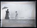 Due donne con l'abito lungo e un parasole a passeggio sulla spiaggia: Bellaria