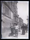 Un uomo con un carretto trainato da un cavallo mentre passa davanti al Palazzo Comunale verso la piazza Vittorio Emanuele II: Bologna