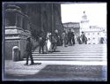 Le persone sulla scalinata e sul sagrato della basilica di San Petronio: prospetto della piazza Vittorio Emanuele II con il palazzo dei Notai sulla via de’ Pignattari e la torre dell’orologio del Palazzo Comunale: Bologna