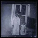La signora Rosa, una bambina e una giovane donna davanti all’ingresso di una casa