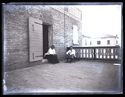 Maria Nigrisoli seduta sul gradino dell’ingresso e un giovane uomo seduto su uno sdraio nel terrazzo del villino: Bellaria