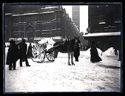 Un uomo che spala e un calesse carico di neve fra la basilica di San Petronio e il palazzo dei Notai: piazza Vittorio Emanuele II: Bologna