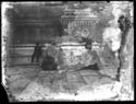 Un uomo e un gruppetto di donne sedute sullo zoccolo della basilica di San Petronio fra il portale mediano, detto porta Magna, e il portale destro: piazza Vittorio Emanuele II: Bologna