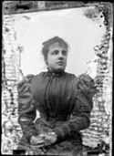 Ritratto di una giovane donna con un abito con la manica gigot: set fotografico allestito nel cortile interno della Biblioteca Universitaria di Bologna