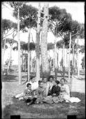 Un bambino, Antonietta Matteucci, Lina Guerrini, Delia Poletti, Maria Nigrisoli, Guido Guerrini e Caterina Frontali seduti, in posa, nella pineta di Classe presso Ravenna