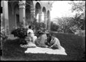 Lina Guerrini seduta sopra un telo con altri e una donna sulla panca che legge un libro nel giardino davanti al loggiato della villa di Gaibola, detta la Vigna: Bologna
