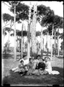 Un bambino, Antonietta Matteucci, Lina Guerrini, Delia Poletti, Maria Nigrisoli, Guido Guerrini e Caterina Frontali seduti, in posa, nella pineta di Classe presso Ravenna