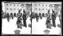 Una donna a passeggio che guarda l’obiettivo fotografico e un uomo che fuma la pipa in piazza Vittorio Emanuele II: prospetto del Palazzo Comunale: Bologna