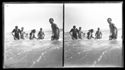 Un gruppo di giovani uomini e donne fanno il bagno nel mare mosso: Bellaria
