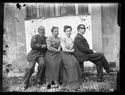 Ritratto della famiglia Guerrini: Olindo, Maria Nigrisoli, Lina e Guido seduti su una panca nel cortile interno della Biblioteca Universitaria di Bologna