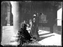 Una donna con un cappellino e i guanti a passeggio sotto il portico del Pavaglione verso la via Farini: Bologna