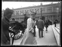 Una giovane donna che guarda l’obiettivo fotografico e una carrozza con il cocchiere in sosta davanti alla scalinata della basilica di San Petronio in piazza Vittorio Emanuele II: prospetto del Portico e Palazzo dei Banchi: Bologna