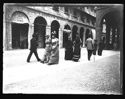 Tre coppie di donne e due uomini a passeggio, in direzione opposta, fra la piazza Cavour e la via Farini: Bologna