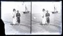 Caterina Frontali con l’accappatoio e Lina Guerrini in costume da bagno in piedi sulla battigia: in secondo piano le operazioni di ormeggio di una barca: Bellaria
