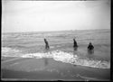 Tre bambini con gli abiti e un cappello nella riva: Bellaria