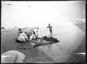 Un bambino e due uomini puliscono la rete sulla battigia dopo la pesca a strascico: Bellaria