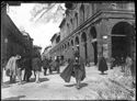 Un uomo a passeggio verso la via Rizzoli e un gruppetto che fa conversazione, un uomo con un carrettino e il tramway a cavallo numero 8 nella via Ugo Bassi: incrocio delle vie Ugo Bassi, dell’Indipendenza e Rizzoli con veduta sulla via Ugo Bassi: Bologna