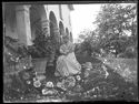 Maria Nigrisoli con un abito a righe seduta su una sedia nel giardino davanti al loggiato della villa di Gaibola, detta la Vigna: Bologna