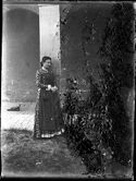 Maria Nigrisoli con un abito con grembiule appoggiata ad una colonna del loggiato della villa di Gaibola, detta la Vigna: Bologna