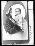 Ritratto di una donna con una bambina in braccio da una fotografia di Andrea Vidau e figlio puntata ad una pagina manoscritta con istruzioni tecniche per lo sviluppo delle lastre negative