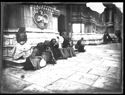 Una bambina e sei donne che fanno conversazione, sedute sullo zoccolo, fra il portale mediano, detto porta Magna, e il portale destro della basilica di San Petronio: piazza Vittorio Emanuele II: Bologna