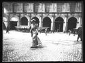 Una donna a passeggio verso la basilica di San Petronio e i tramway a cavallo in sosta davanti al palazzo del Podestà: piazza Vittorio Emanuele II: Bologna