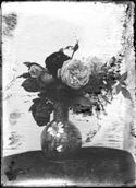 Un vaso decorato con motivi floreali, con un mazzo di rose e appoggiato sopra un tavolino