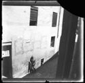 Un uomo all’orinatoio collocato nella parete prospiciente la via San Giacomo dell'edificio all'angolo con via Zamboni, nel quale si trovava l'abitazione di Olindo Guerrini, fotografato da una finestra dell’edificio sul lato opposto della strada: Bologna