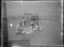 Ritratto della famiglia Guerrini: Olindo, Maria Nigrisoli, Lina e Guido con l’accappatoio seduti sulla spiaggia vicino a una cabina con la tenda: Cesenatico