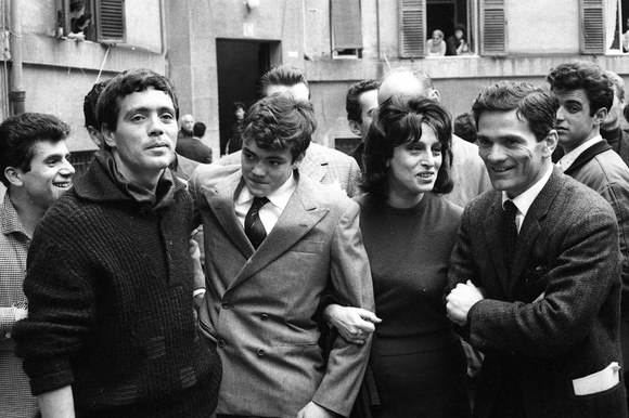 Franco Citti, Ettore Garofolo, Anna Magnani e Pier Paolo Pasolini al Palazzo dei ferrovieri in Piazza Tommaso De Cristoforis, il primo giorno di riprese del film «Mamma Roma». Roma, 17.3.1962