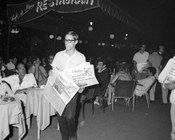 Diffusione del quotidiano su Via Veneto con notizie in prima pagina riguardanti la Guerra in Vietnam. Roma, 24.7.1967