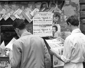 Lettori di fronte a un'edicola con l’edizione  straordinaria de «l’Unità» con la notizia del lancio del satellite sovietico Sputnik 3. Roma, 15.5.1958