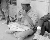 Un lavoratore edile durante la pausa del pranzo legge il quotidiano con l’annuncio di uno sciopero per il giorno successivo. Roma, 9.5.1963