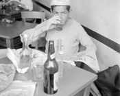 Un lavoratore edile durante la pausa del pranzo legge il quotidiano con l’annuncio di uno sciopero per il giorno successivo. Roma, 9.5.1963