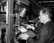 Operaio tipografo che opera alla tastiera della linotype. Stabilimento Tipografico G.A.T.E. Roma, gennaio 1957