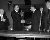 Il Presidente del Consiglio Aldo Moro consegna a Federico Fellini l’Oscar per il film «8 ½» alla presenza del produttore Angelo Rizzoli e del Ministro dello spettacolo Achille Corona. Teatro di posa Safa-Palatino al Celio - Roma, 26.4.1964