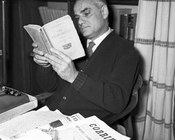 Alberto Moravia nella casa di via dell’Oca mentre legge la quarta edizione Alpes de Gli indifferenti. Roma, 1956 