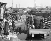 Ph. Rodrigo Pais | Approvvigionamento dell'acqua tra le baracche di Borghetto Prenestino, Roma, agosto 1968