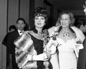 Giovanna Lloyd de Blanck, con abito di Emilio Schuberth e gioiello Boucheron, e Silvana Pampanini, con abito di Mingolini-Gugenheim e pelliccia di Bertoletti, alla serata inaugurale della stagione al Teatro dell’Opera. Roma, 16.12.1961